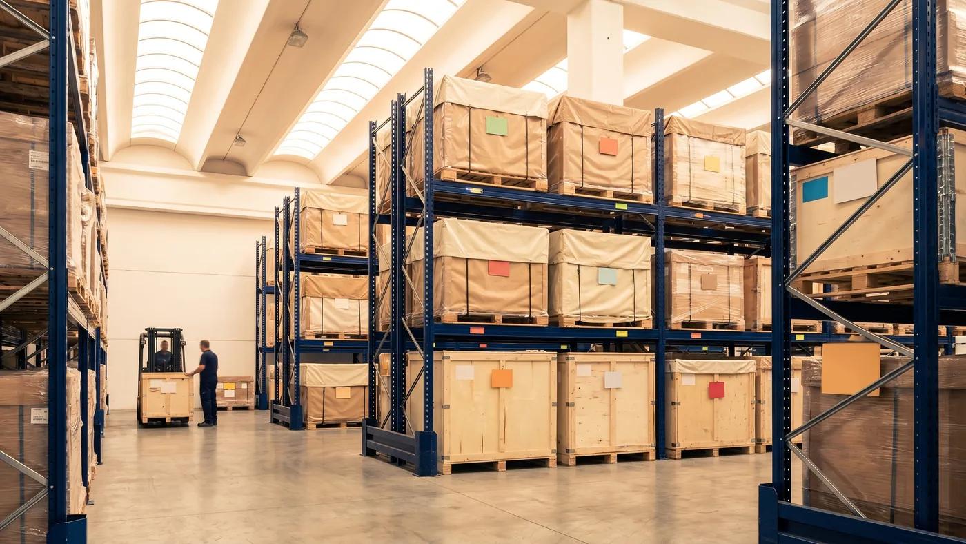 Italian warehouse aisle with multi-level pallet racking and labelled inventory, Delta Novel pallet storage in Ravenna.